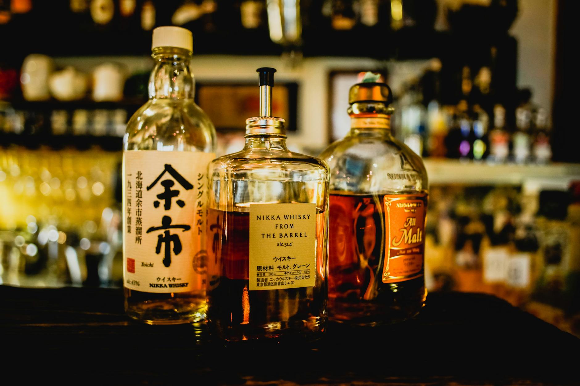 Yamazaki vs Hakushu Japanese whisky bottles on a wooden table
